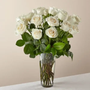 A tall glass vase with white roses
