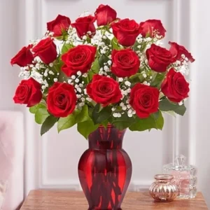 A red vase with red roses and white flowers