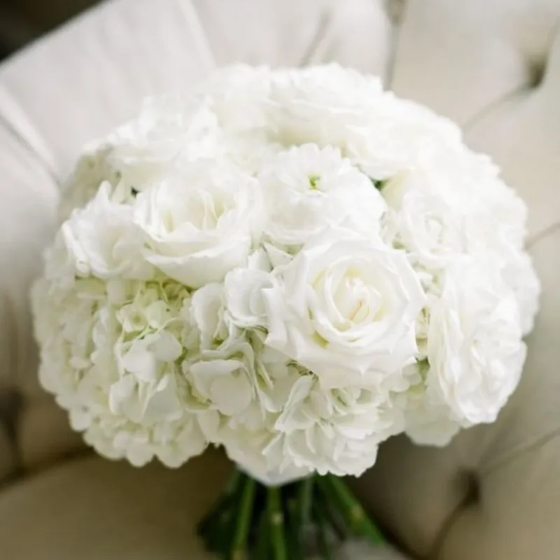 A bouquet of white roses on a couch