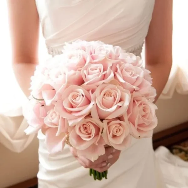 A person holding light pink roses