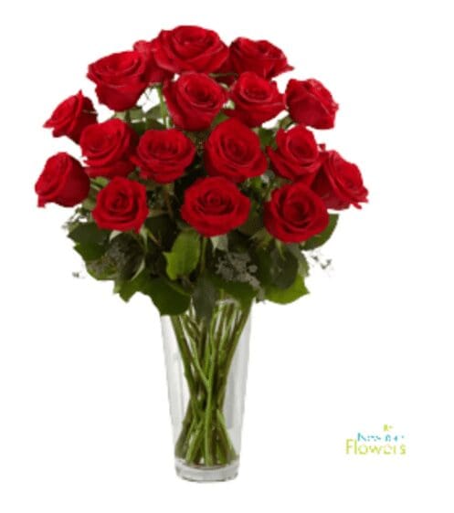 A tall glass vase with red roses