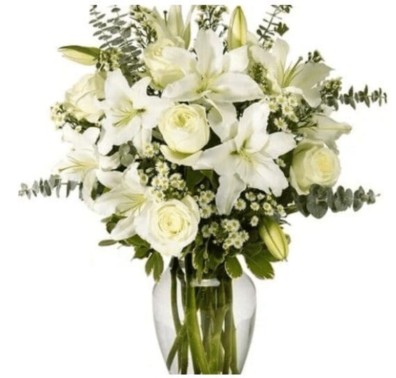 A glass vase with white lilies and roses