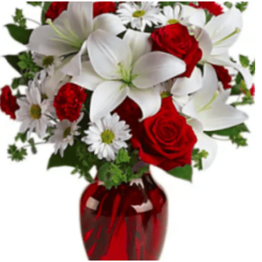 White daisies and red roses in a glass vase