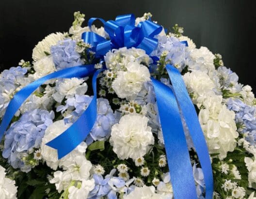 A bouquet of blue and white flowers with a blue ribbon