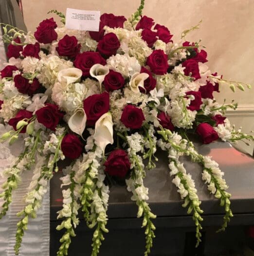 Red roses and white tulips over a coffin