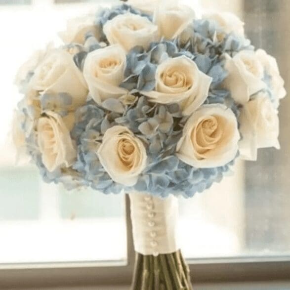 A bundle of white roses and powder blue flowers
