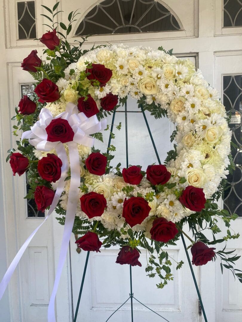 A wreath made of white flowers and red roses