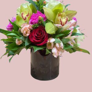 A black gift box with assorted pink flowers