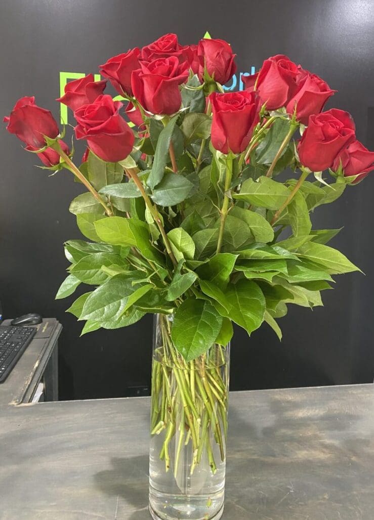 A red vase with assorted pink flowers