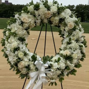 A white floral wreath displayed outdoors