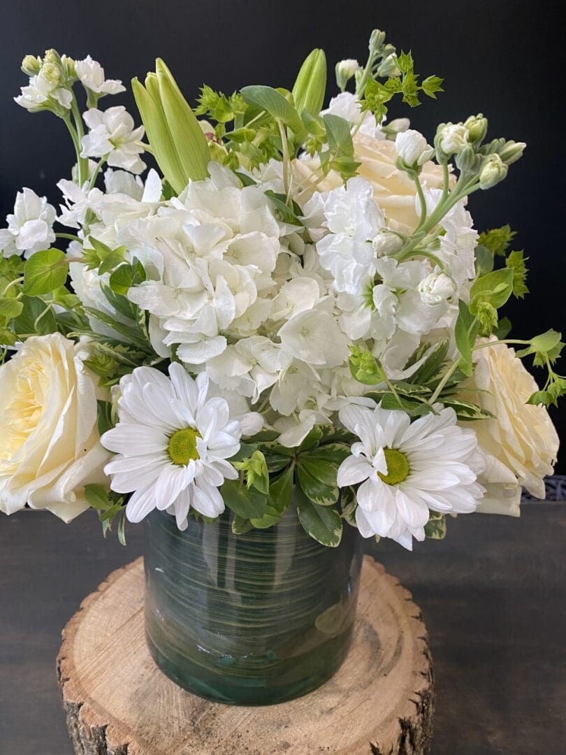 A vase with white and light yellow flowers