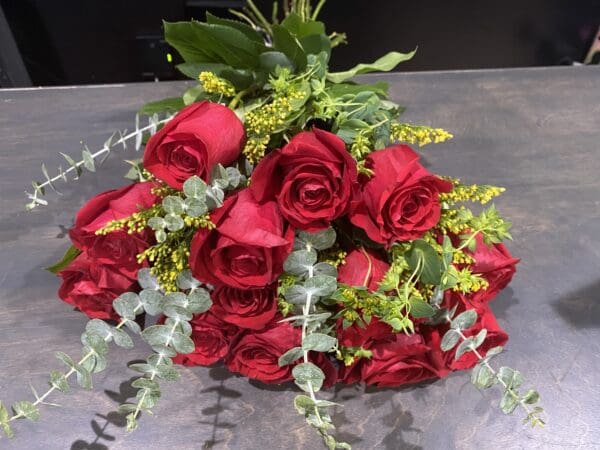 A bouquet of red roses with small yellow flowers
