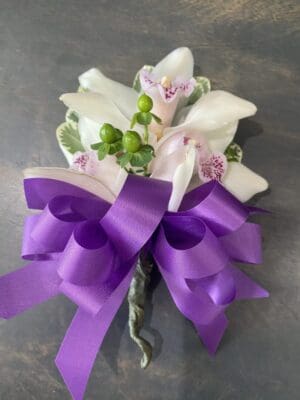 White flowers wrapped with a purple ribbon