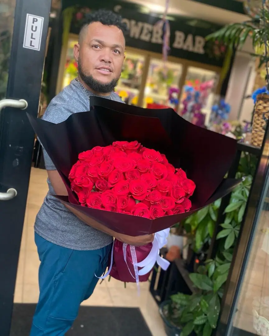 A man holding a bouquet of red roses