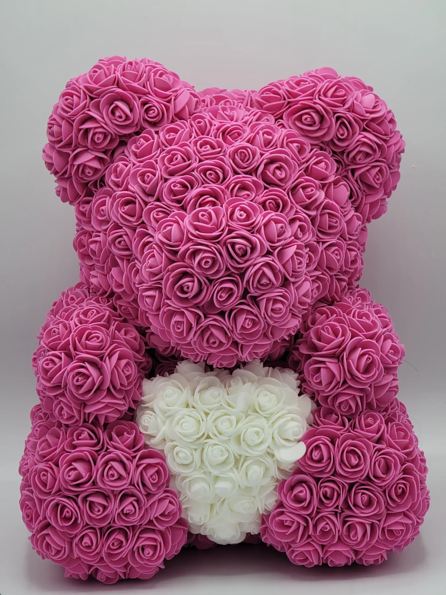 A sitting bear made of pink and white roses