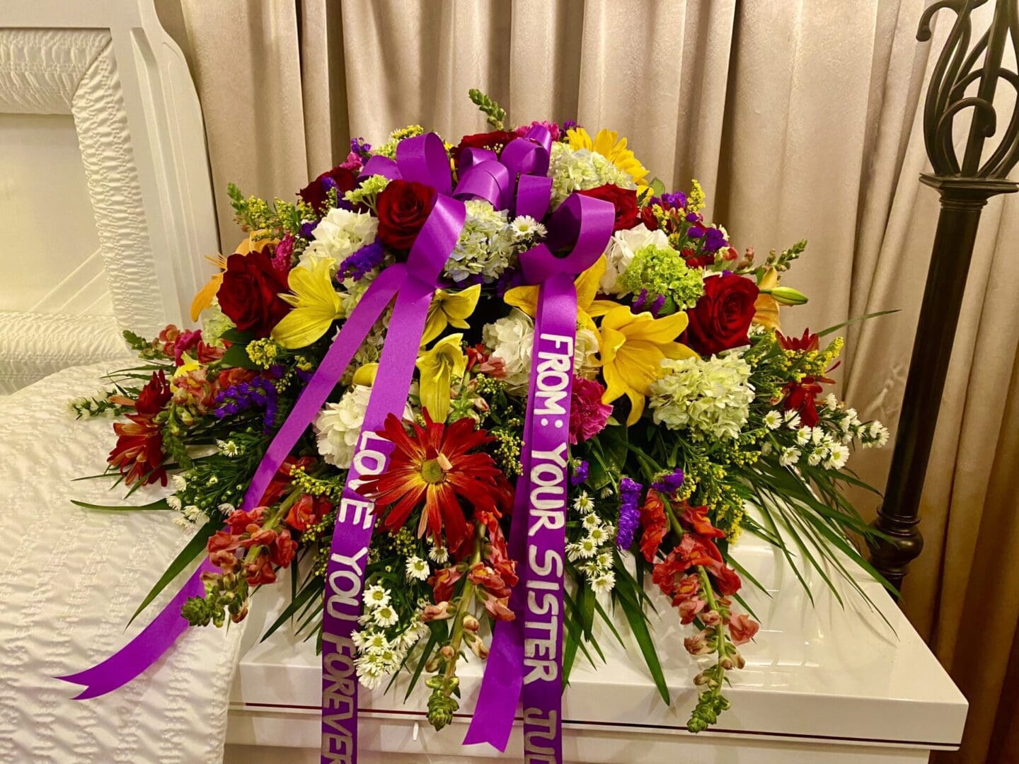 Gregory casket flowers with ribbons