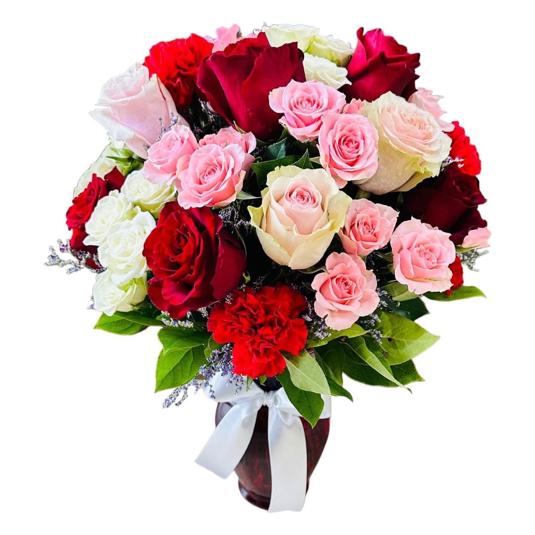 A bouquet of red, pink, and white roses with green foliage and a white ribbon.