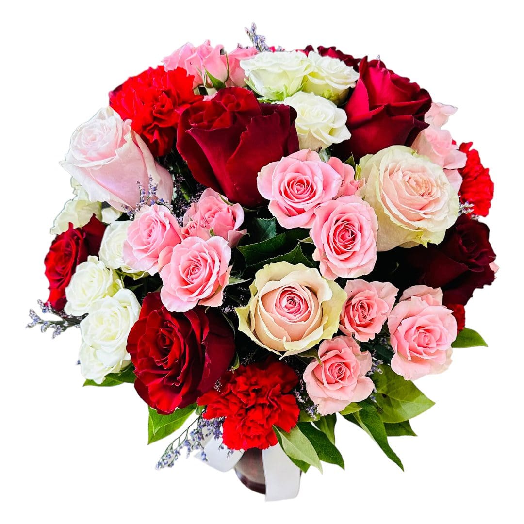A bouquet of red, pink, and white roses with green leaves and decorative fillers.