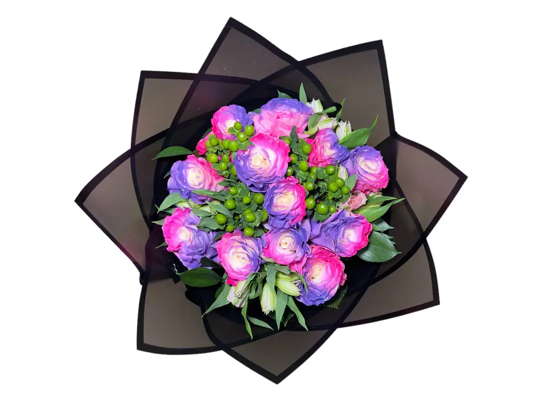 A 12 PAYASITOS PREMIUM ROSES BOUQUET of purple roses and green berries arranged on a dark backdrop with geometric shapes.