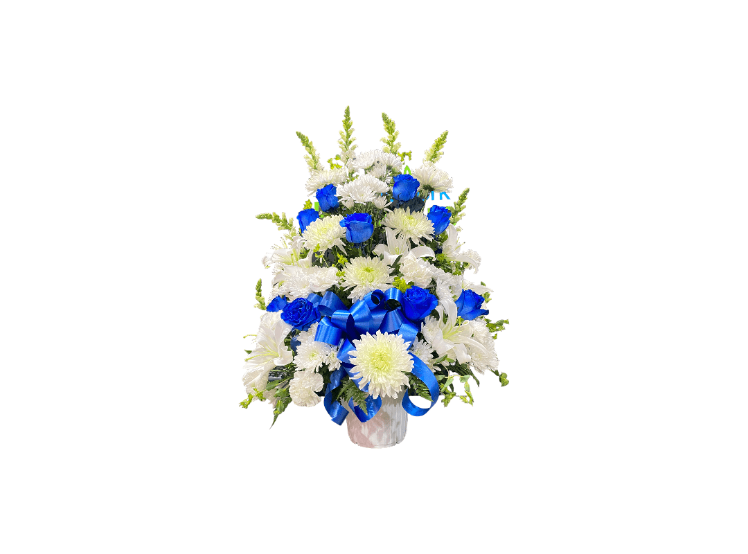 Bouquet of blue and white flowers with green foliage in a white vase.