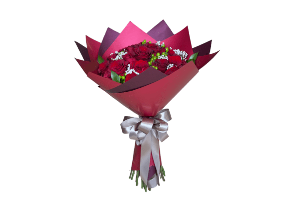 A bouquet of red roses wrapped in dark pink paper with a silver bow.