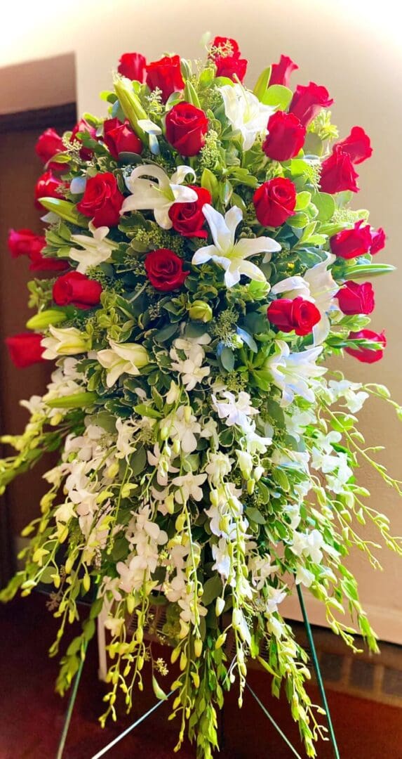 A vibrant floral arrangement featuring red roses and white blossoms with green foliage.