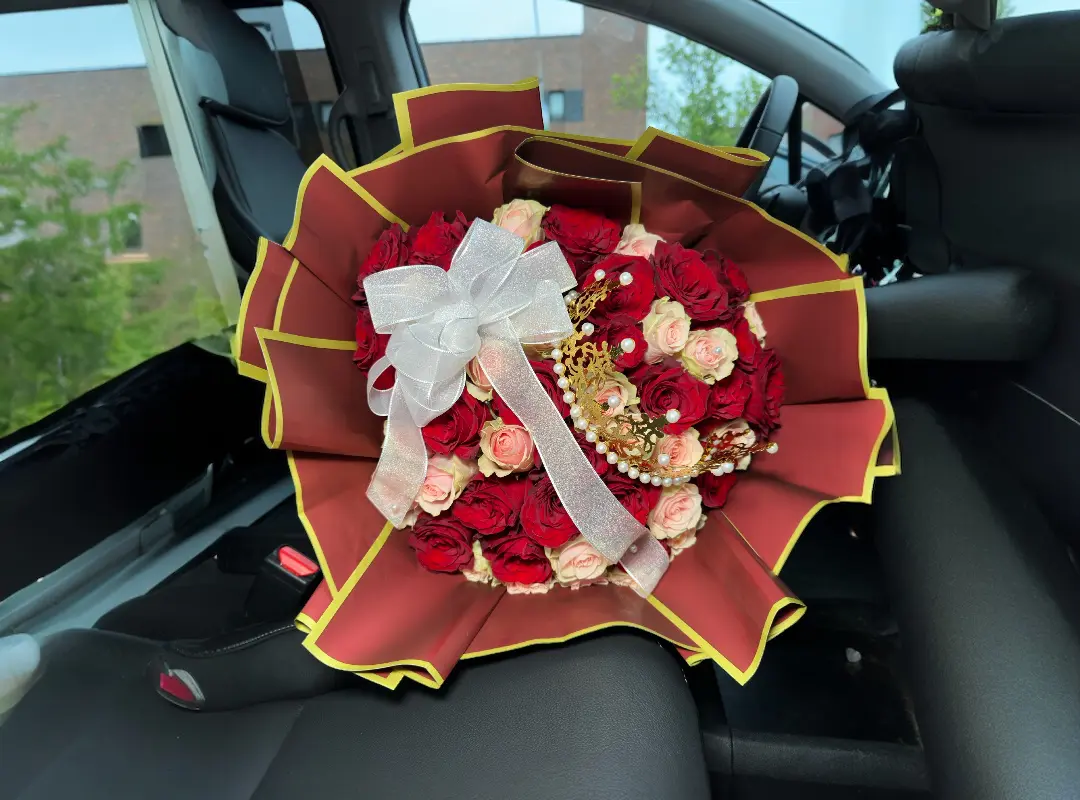 Red and pink roses bouquet in car seat.
