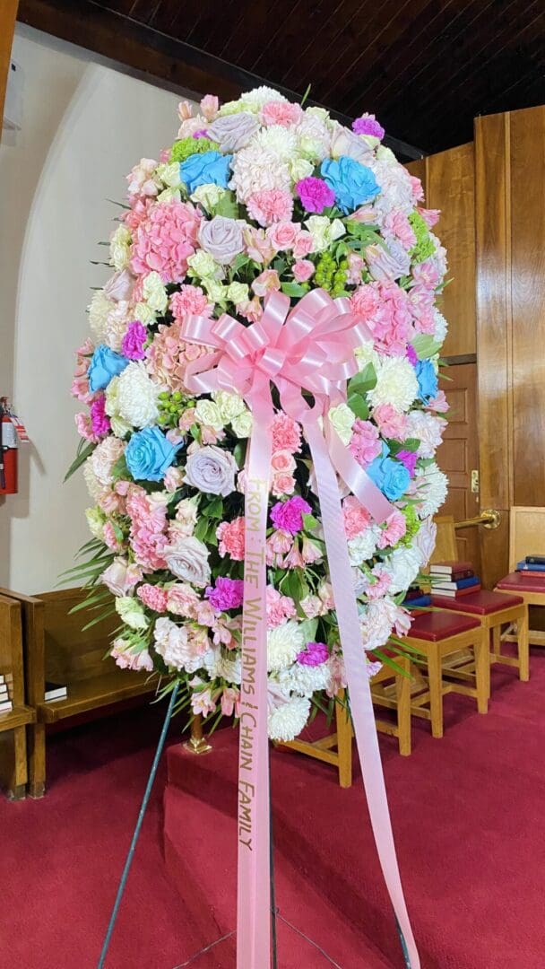 Pink and blue floral arrangement with ribbon.